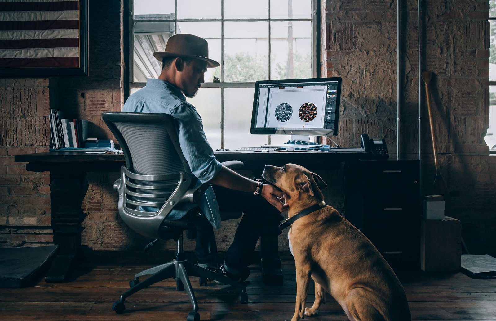 Dog beside a person working at a desk